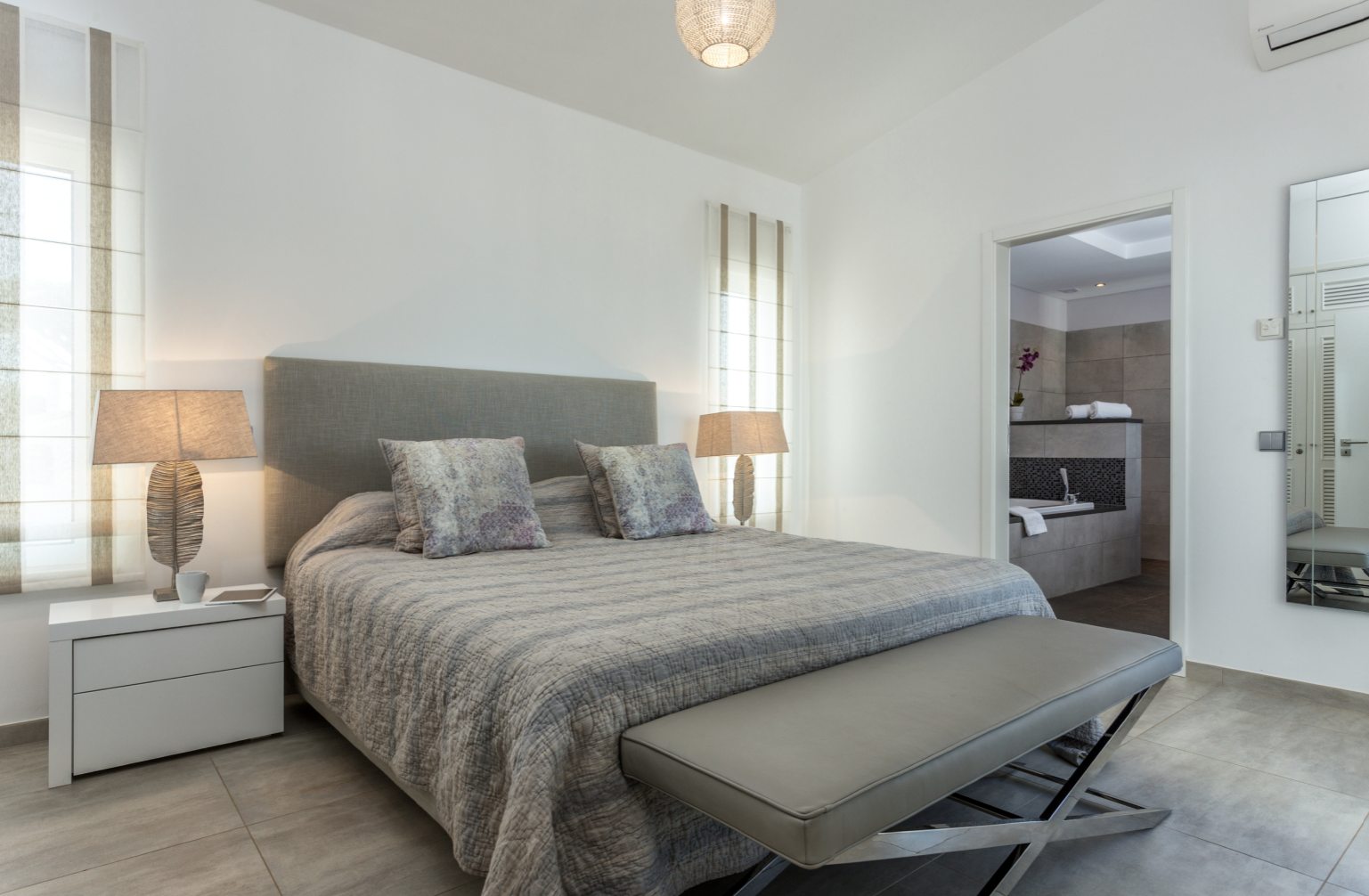 a bed with two white nightstands in a guest bathroom